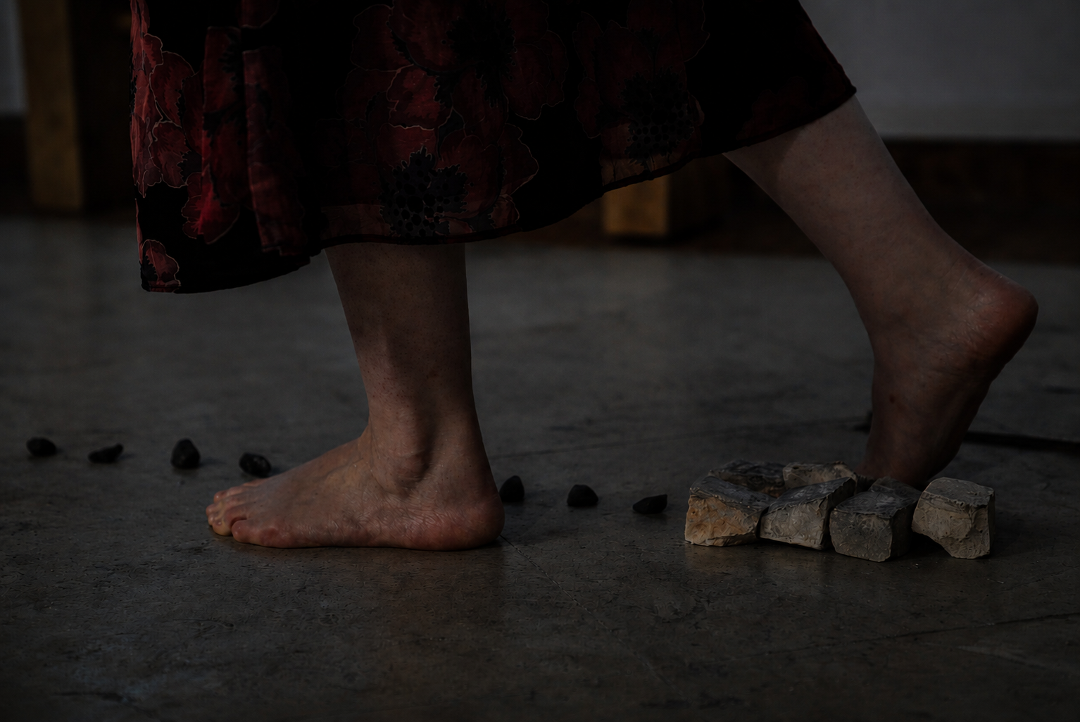 Bare feet stepping on stones along a ritual line